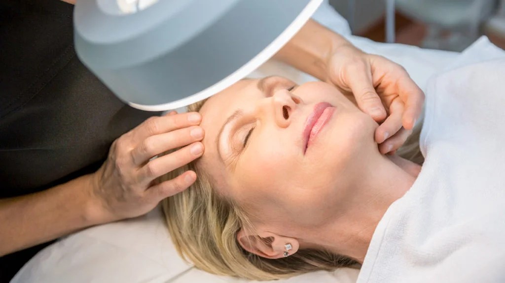 Facial Skin Examination A professional examining a woman's face before a skin procedure.